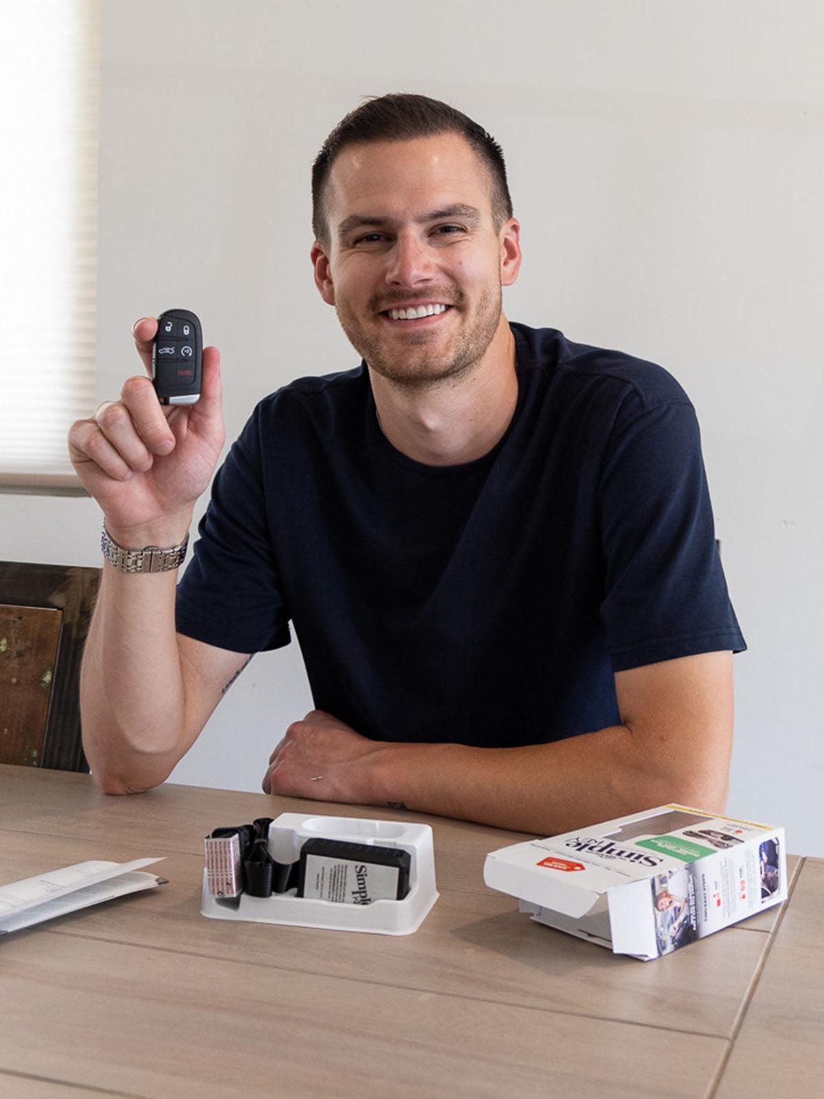 man smiling holding simple key kit 